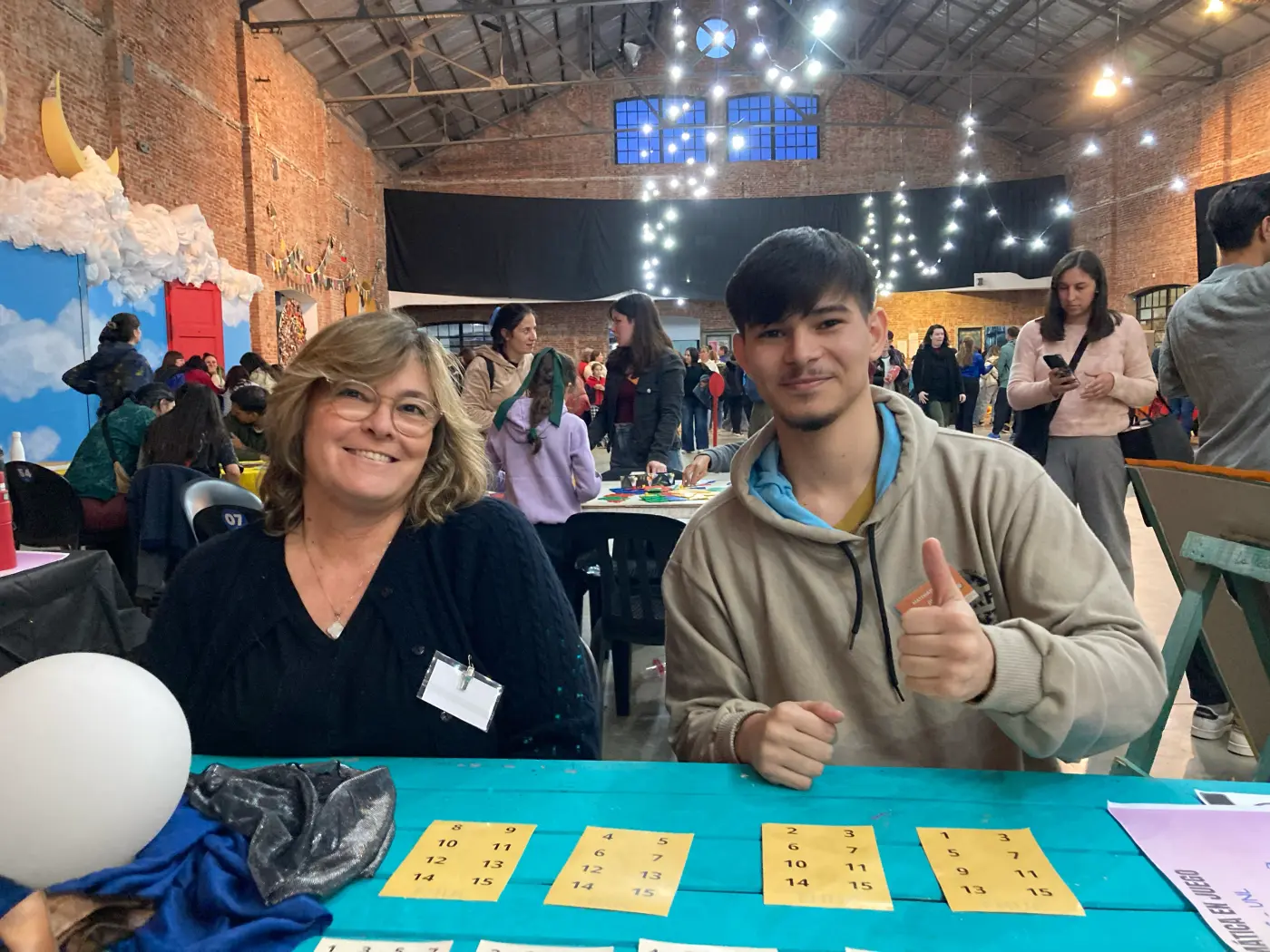 Profesora y estudiante sentados a una mesa sobre la que hay tarjetas con números
